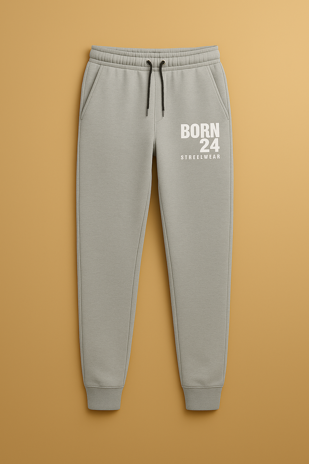 Gray sweatpants with 'BORN 24' text on a brown background