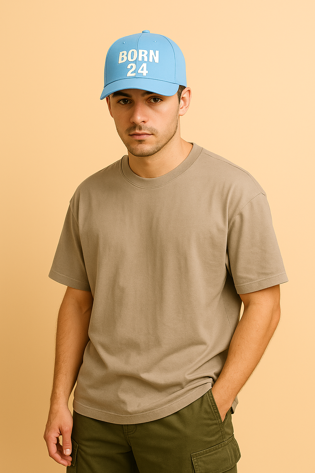 Man wearing a blue cap with 'BORN 24' text and a beige t-shirt on a beige background